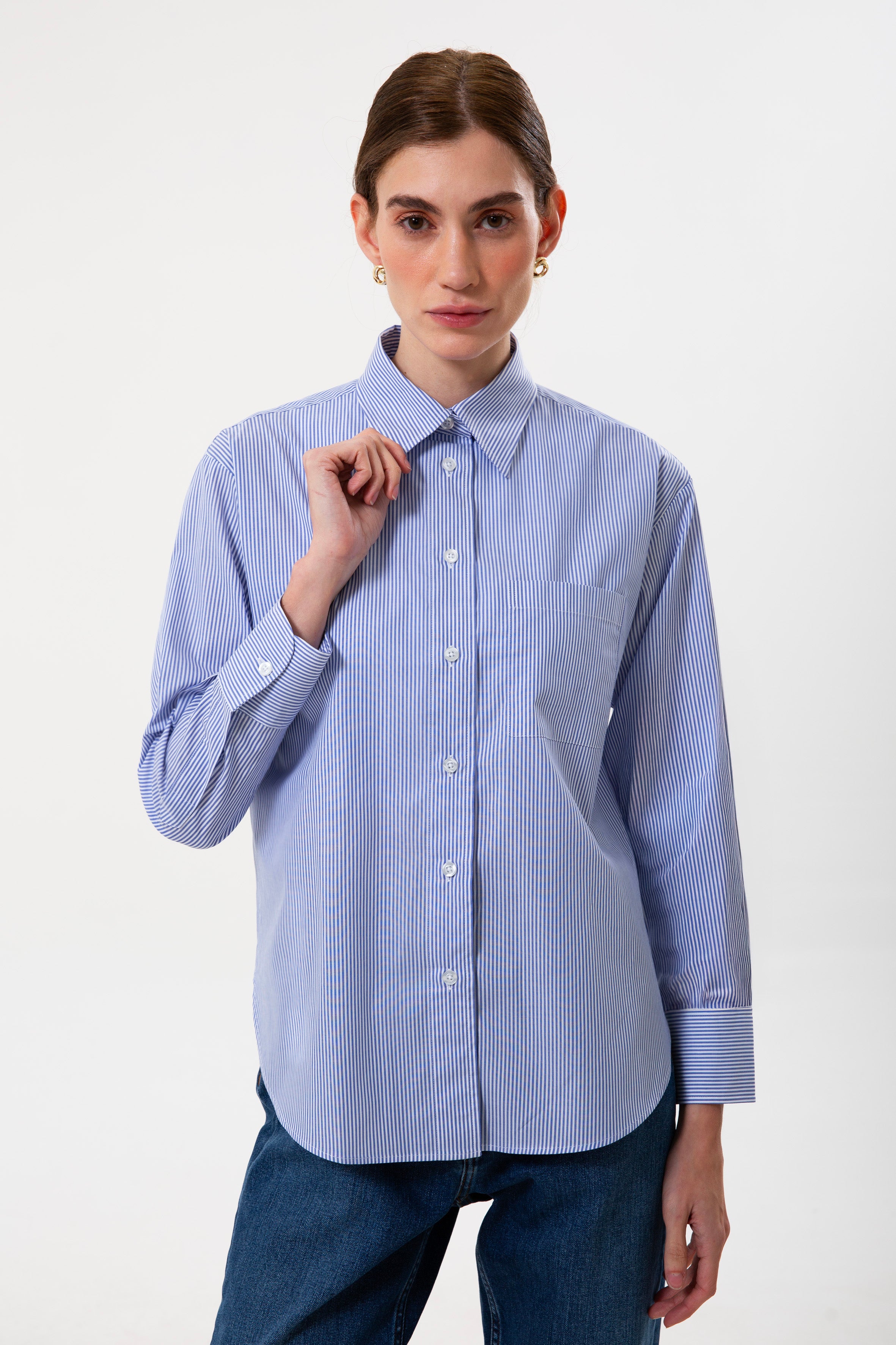 Mavi çizgili %100 pamuk kadın gömlek; uzun kollu, bol kesim ve nefes alan doğal kumaşıyla günlük kullanım için idealdir. Rahat kalıbı ve şık çizgili deseniyle hem ofis stiline hem de özel gün kombinlerine uyum sağlar.
