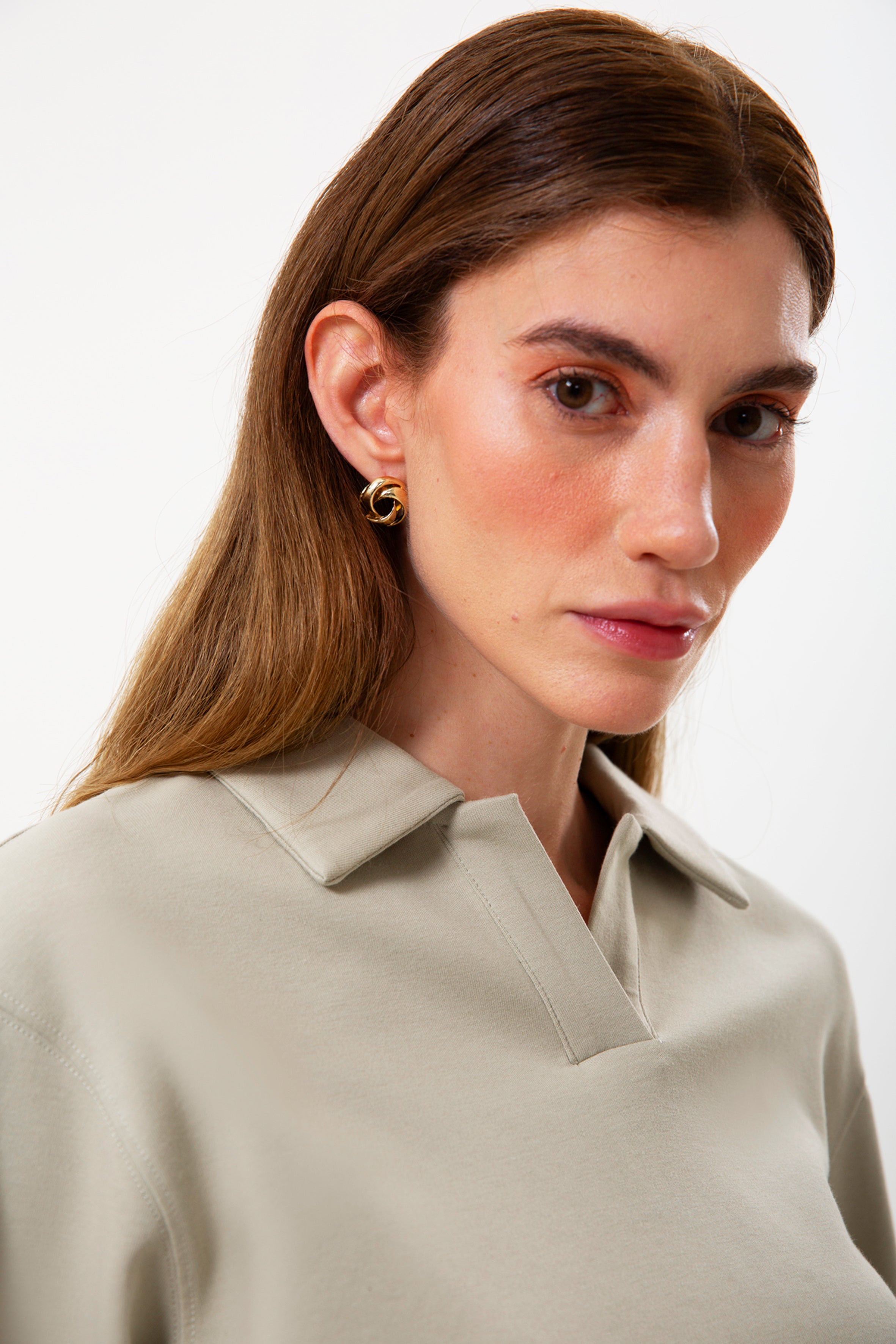 Organik pamuklu dokusu ve polo yaka formuyla modern bir sweatshirt görünümü sunar. Bej tonunun net ifadesi, oversize kalıpla birleşerek gün boyu doğal ve geniş bir rahatlık sağlar. Yumuşak yüzeyi, nefes alan yapısı ve minimal detaylarıyla her gün giyilmeye uygun, zamansız bir parça.