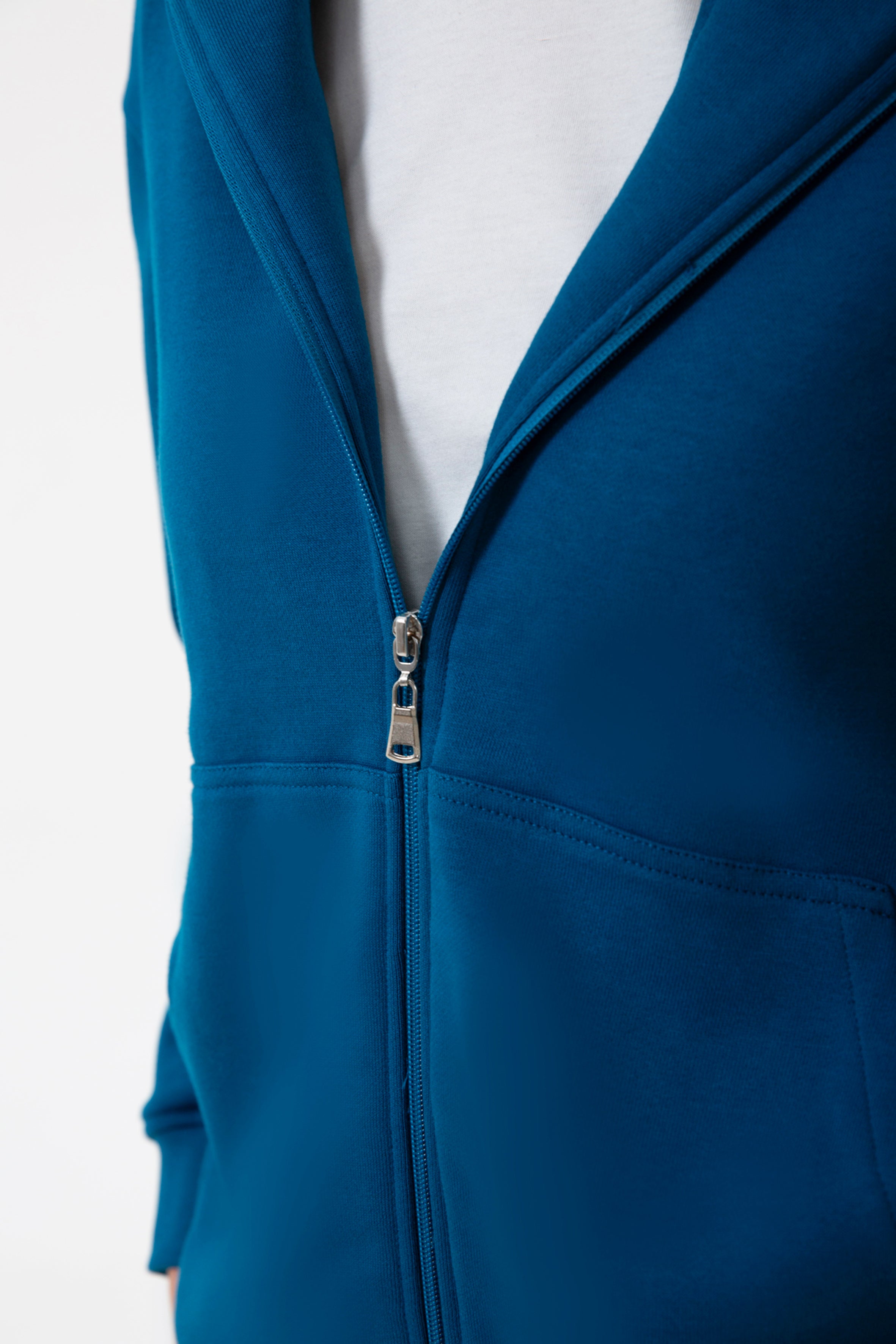 Günlük stile zahmetsiz bir uyum sağlayan bu petrol mavisi kapüşonlu sweatshirt, yumuşak dokusu ve rahat kesimiyle her mevsimde konfor sunar. Minimal çizgilere sahip regular fit formu, şehir hayatından ev rahatlığına kadar her ortamda doğal bir şıklık yaratır.
Fermuarlı tasarımı sayesinde katmanlı kombinlere kolayca uyum sağlayan bu kadın sweatshirt; nefes alan yapısı, sade görünümü ve işlevsel kapüşonuyla gün boyu sıcak ve konforlu bir kullanım sunar.