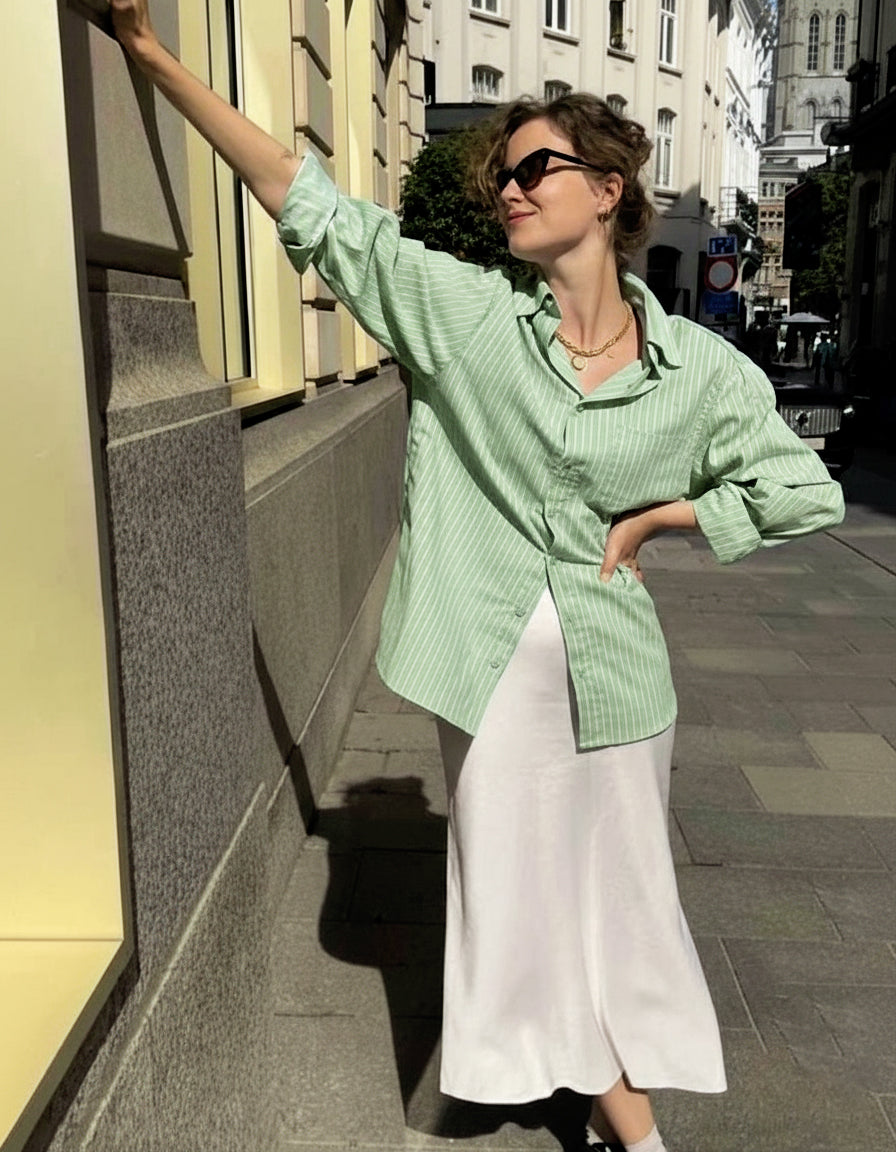 Yeşil çizgili %100 pamuk kadın gömlek; uzun kollu, bol kesim ve nefes alan doğal kumaşıyla günlük kullanım için idealdir. Rahat kalıbı ve şık çizgili deseniyle hem ofis stiline hem de özel gün kombinlerine uyum sağlar.