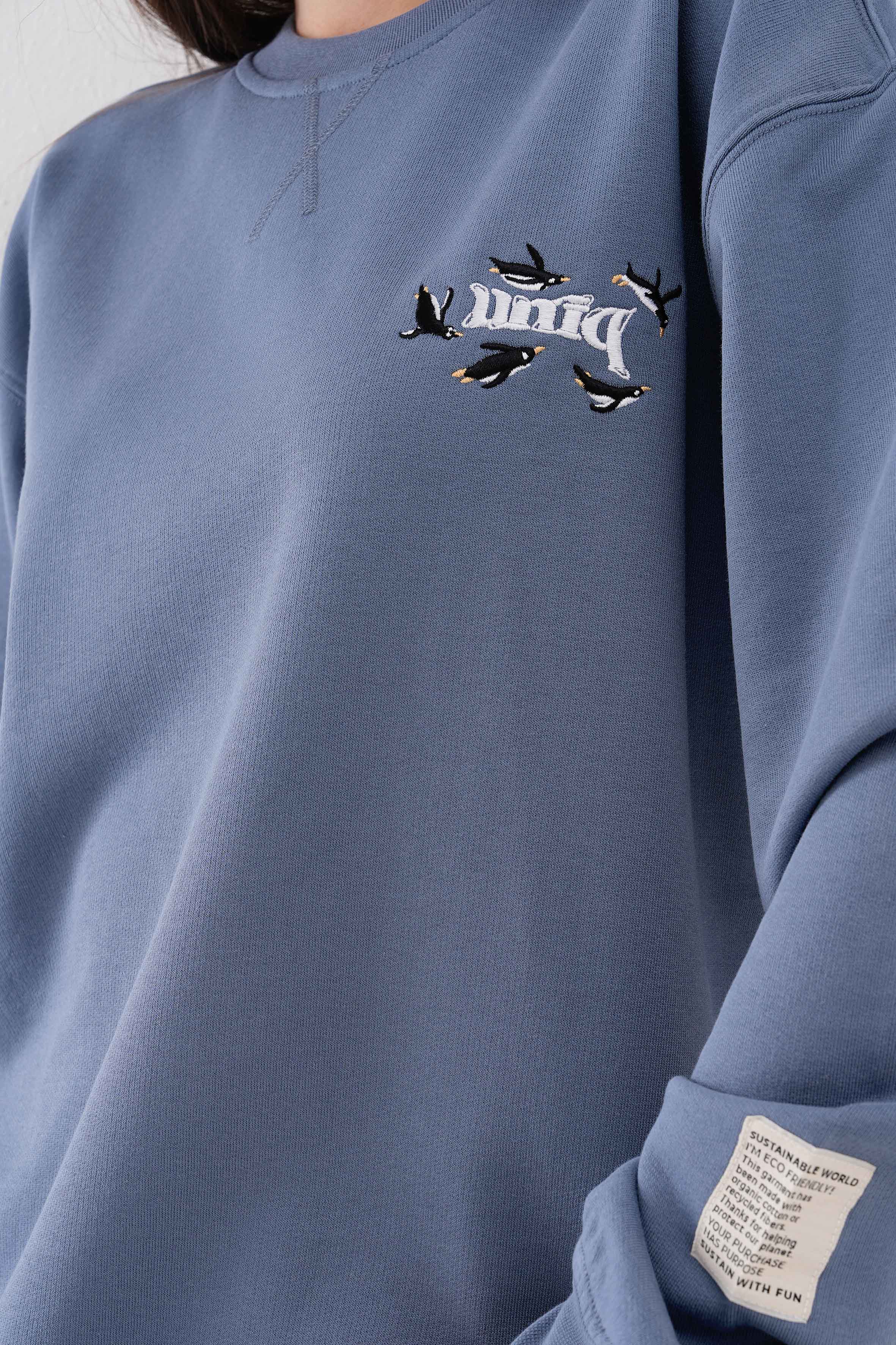 Penguen nakışlı organik pamuklu kadın sweatshirt ile kışın sıcacık geçsin! %100 organik pamuk kumaşıyla yumuşak, nefes alabilir ve çevre dostu bir seçim. Sürdürülebilir moda ile tarzını tamamla!