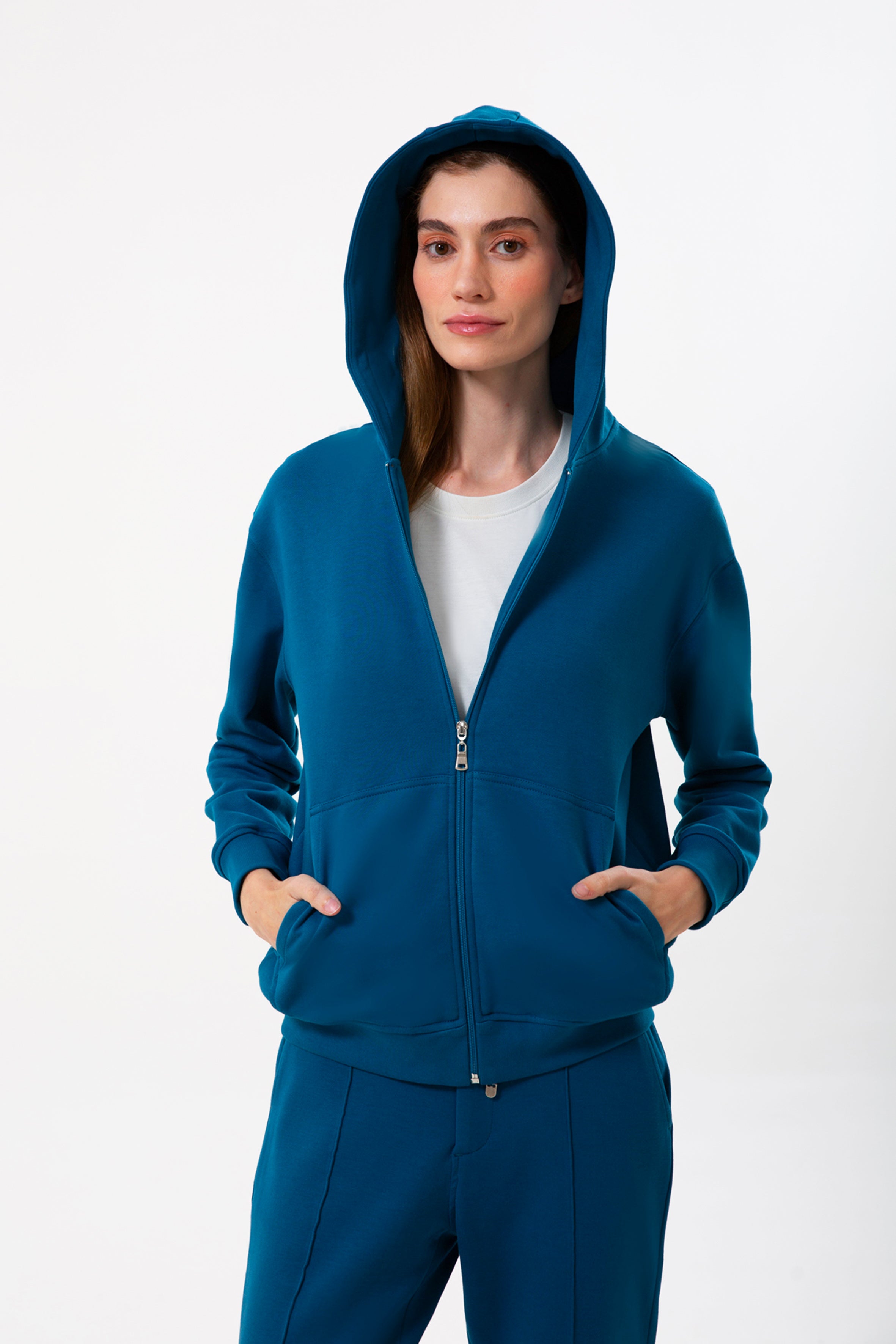 Günlük stile zahmetsiz bir uyum sağlayan bu petrol mavisi kapüşonlu sweatshirt, yumuşak dokusu ve rahat kesimiyle her mevsimde konfor sunar. Minimal çizgilere sahip regular fit formu, şehir hayatından ev rahatlığına kadar her ortamda doğal bir şıklık yaratır.
Fermuarlı tasarımı sayesinde katmanlı kombinlere kolayca uyum sağlayan bu kadın sweatshirt; nefes alan yapısı, sade görünümü ve işlevsel kapüşonuyla gün boyu sıcak ve konforlu bir kullanım sunar.